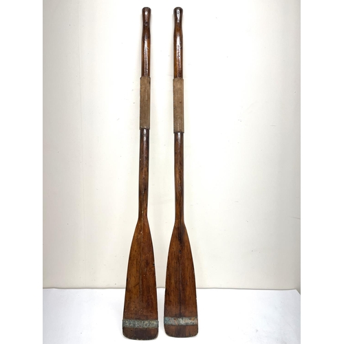 226 - Pair of early 20th century wooden boating oars, suede grips, L121cm