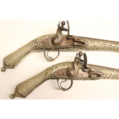 103 - Pair of Balkan silver covered decorative flintlock pistols, 9.5