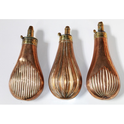 179 - Three brass and copper powder flasks, with ribbed design. One by Dixon and Sons