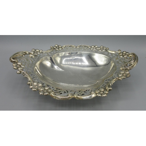 244 - Edwardian silver dish in oval form with pierced scrolling boarders and flowers cast in relief, stood... 