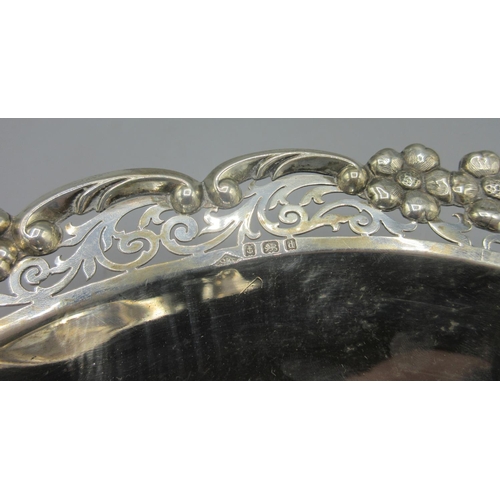 244 - Edwardian silver dish in oval form with pierced scrolling boarders and flowers cast in relief, stood... 