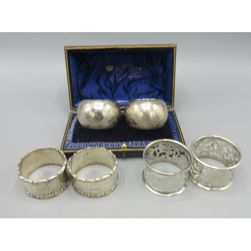 252 - Cased pair of Victorian silver napkin rings with vacant cartouche and engraved with floral decoratio... 