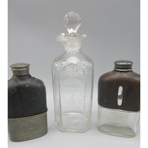 1168 - Two Edwardian hip flasks with leather covered shoulders, and a 19th century engraved 'Gin' decanter,... 