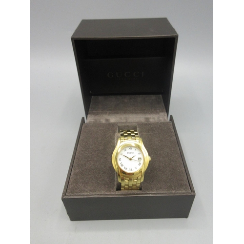 522 - Gucci 2001 lady's gold plated quartz wristwatch with date on integrated bracelet with signed deploym... 