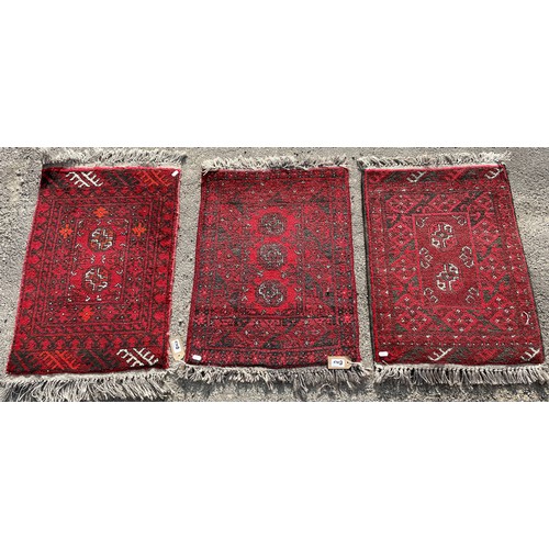 676 - Three small 20th Century red ground Afghan rugs, 72cm x 50cm