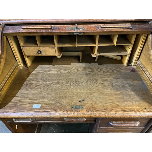 755 - 20th century oak single pedestal serpentine roll top desk, W91cm D66cm H109cm