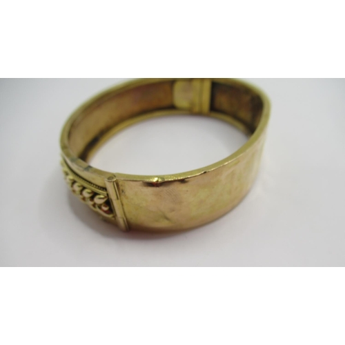 2 - Yellow metal hinged bangle with Etruscan style detail, 13.58g