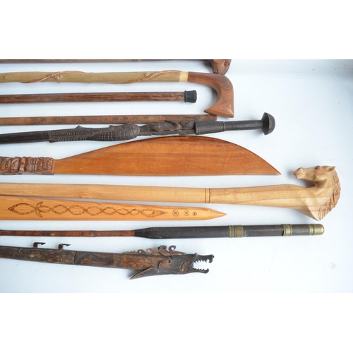 1300 - Collection of wooden walking sticks, sword, tribal style paddle, an African carved bust (H47cm), car... 