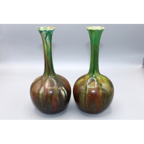 335 - Pair of Burmantofts Faience bottle form vases with green and brown streaked glaze, incised sun motif... 