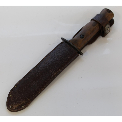 1438 - British military-issue survival knife with wooden handle and leather sheath. Wilkinson Sword stamp t... 