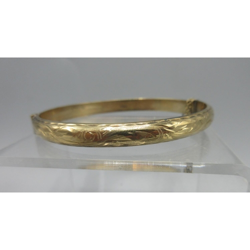 791 - 9ct yellow gold hinged bangle, half engraved with foliate decoration, stamped 375, 8.2g