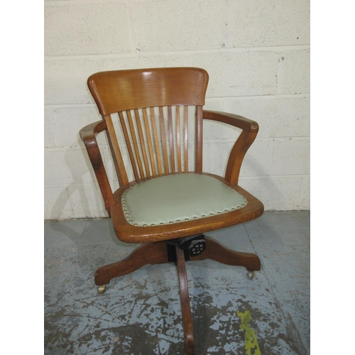 1200 - 20th century oak swivel office arm chair, on four shaped supports with castors