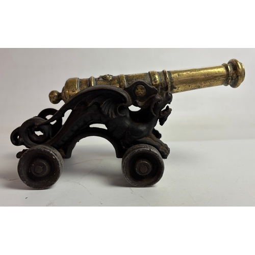 758 - Large Victorian brass model table cannon on mounted cast iron carriage with dragons either side