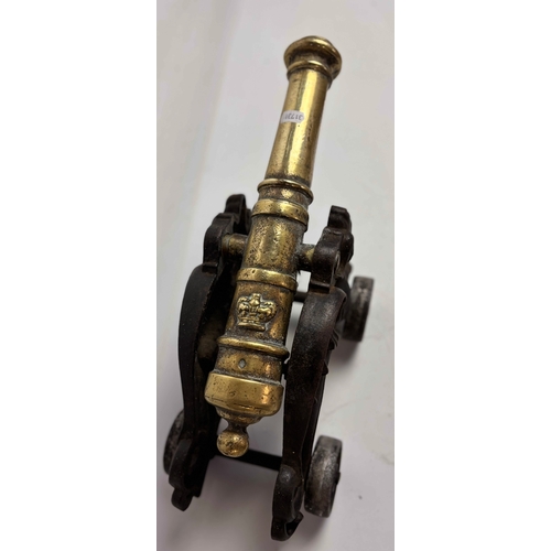 758 - Large Victorian brass model table cannon on mounted cast iron carriage with dragons either side