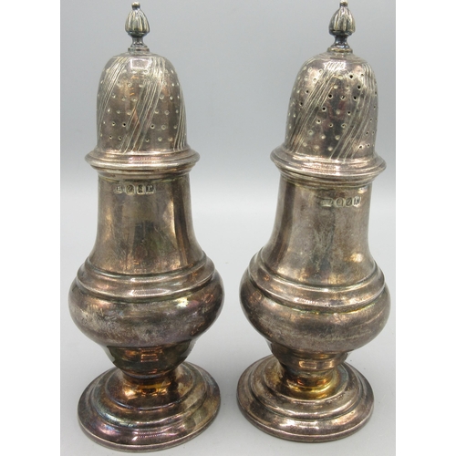 210 - Pair of George V silver pepperettes on circular pedestal bases with urn shaped bodies by Harry Freem... 