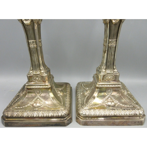 650 - Pair of 20th C silver candlesticks with gadrooned sconces decorated with ribbon swags above square t... 