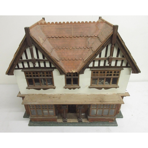 667 - Tudor Style dolls house with wooden furniture and dolls, H57.5cm A/F