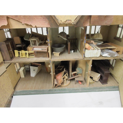 667 - Tudor Style dolls house with wooden furniture and dolls, H57.5cm A/F