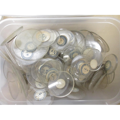 243 - Ten containers containing early 20th Century pocket watch and fob watch glasses