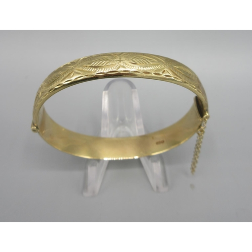 46 - 9ct yellow gold hinged bangle, half with engraved detail, stamped 375, 12.9g