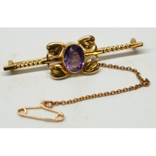 474 - Antique yellow metal brooch set with amethyst surrounded by leaf design, with safety chain, mark wor... 