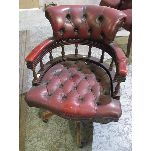 609 - Buttoned red leather Captains type swivel arm chair, on four supports with castors, H86cm