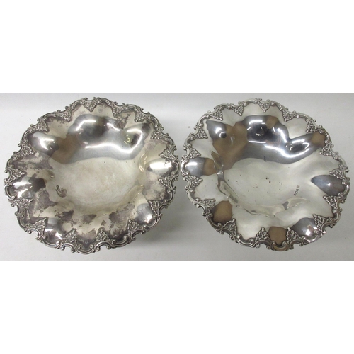 1069 - Pair of Edwardian silver bonbon dishes, scrolling borders with foliate repoussé, on four cabriole le... 