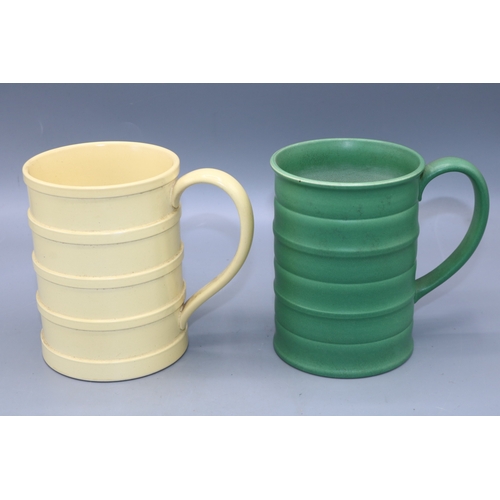 1195 - Keith Murray for Wedgwood, two tankards with ridged decoration, glazed in green and straw yellow, pr... 