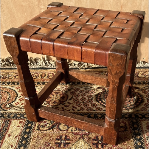 1450 - Robert Mouseman Thompson of Kilburn - an oak rectangular stool, plaited leather top on octagonal bal... 