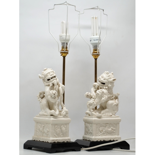 1241 - Pair of Blanc de Chine style table lamps modelled as Dog of Fo groups on rectangular plinths and ebo... 