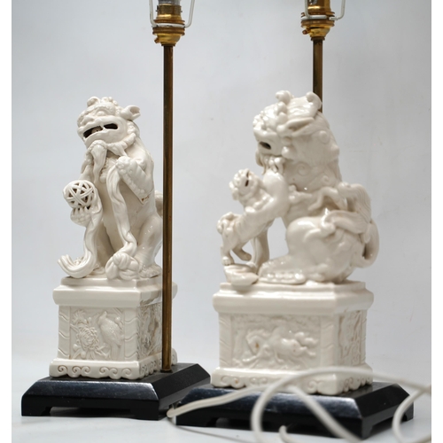 1241 - Pair of Blanc de Chine style table lamps modelled as Dog of Fo groups on rectangular plinths and ebo... 