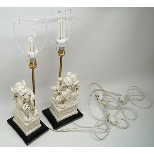 1241 - Pair of Blanc de Chine style table lamps modelled as Dog of Fo groups on rectangular plinths and ebo... 