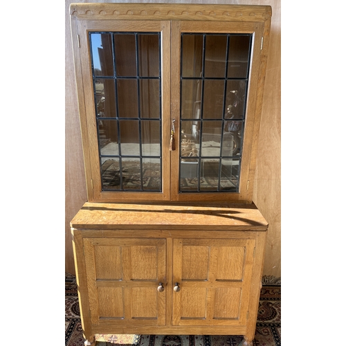 1441 - Robert Mouseman Thompson of Kilburn - a panelled oak side cabinet with penny moulded cornice and two... 