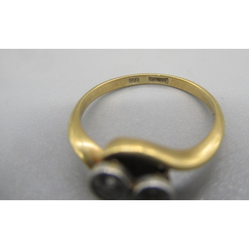 27 - 18ct yellow gold two stone diamond twist ring, the diamonds set in rub over mounts, stamped 18, size... 