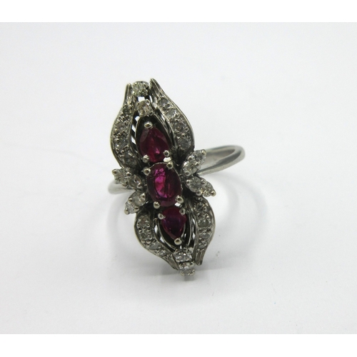 1110 - C1970s white metal three stone cluster ring set with three rubies surrounded by a shaped border set ... 