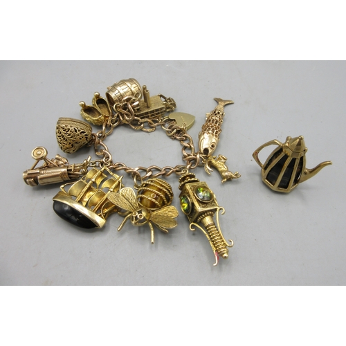 72 - 9ct yellow gold charm bracelet set with 9ct yellow gold charms, including a ship, barrel golf bag, f...