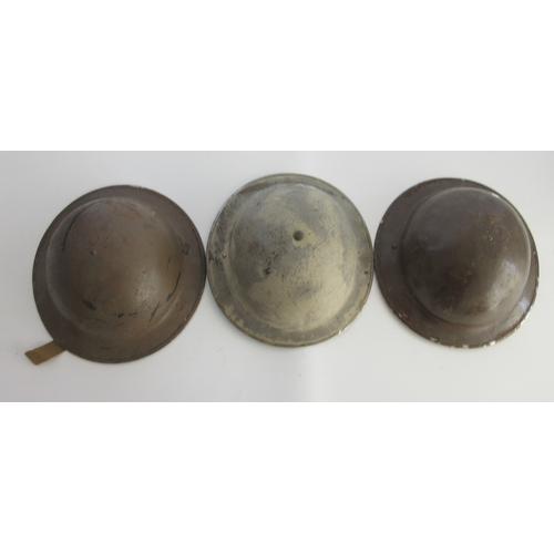 Three WWII British Brodie helmets, two brown painted with full liner and chin strap, grey painted, one lacking liner