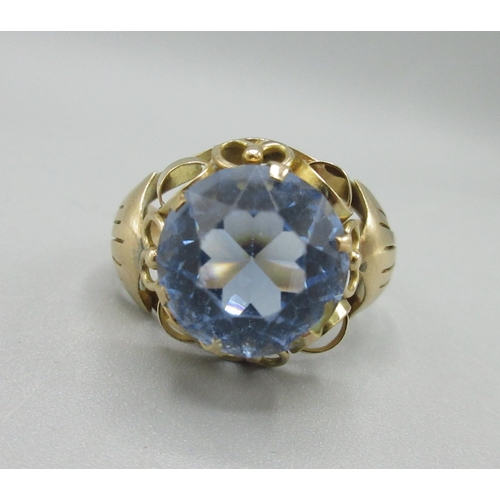 1052 - Yellow metal cocktail ring, large blue stone set in ornate mount, marks indistinct, size Q, 3.9g

Br... 