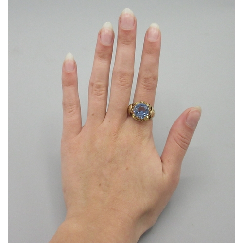 1052 - Yellow metal cocktail ring, large blue stone set in ornate mount, marks indistinct, size Q, 3.9g

Br... 