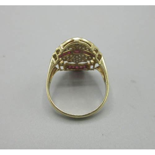 1009 - Art Deco style 18ct yellow gold dress ring adorned with rubies and diamonds, stamped 750, face L25mm... 