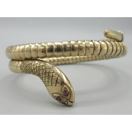 1021 - 9ct rose gold coiled snake bangle with ruby set eyes, stamped 375, 19.2g

Bradleys shipping £23.00 p... 
