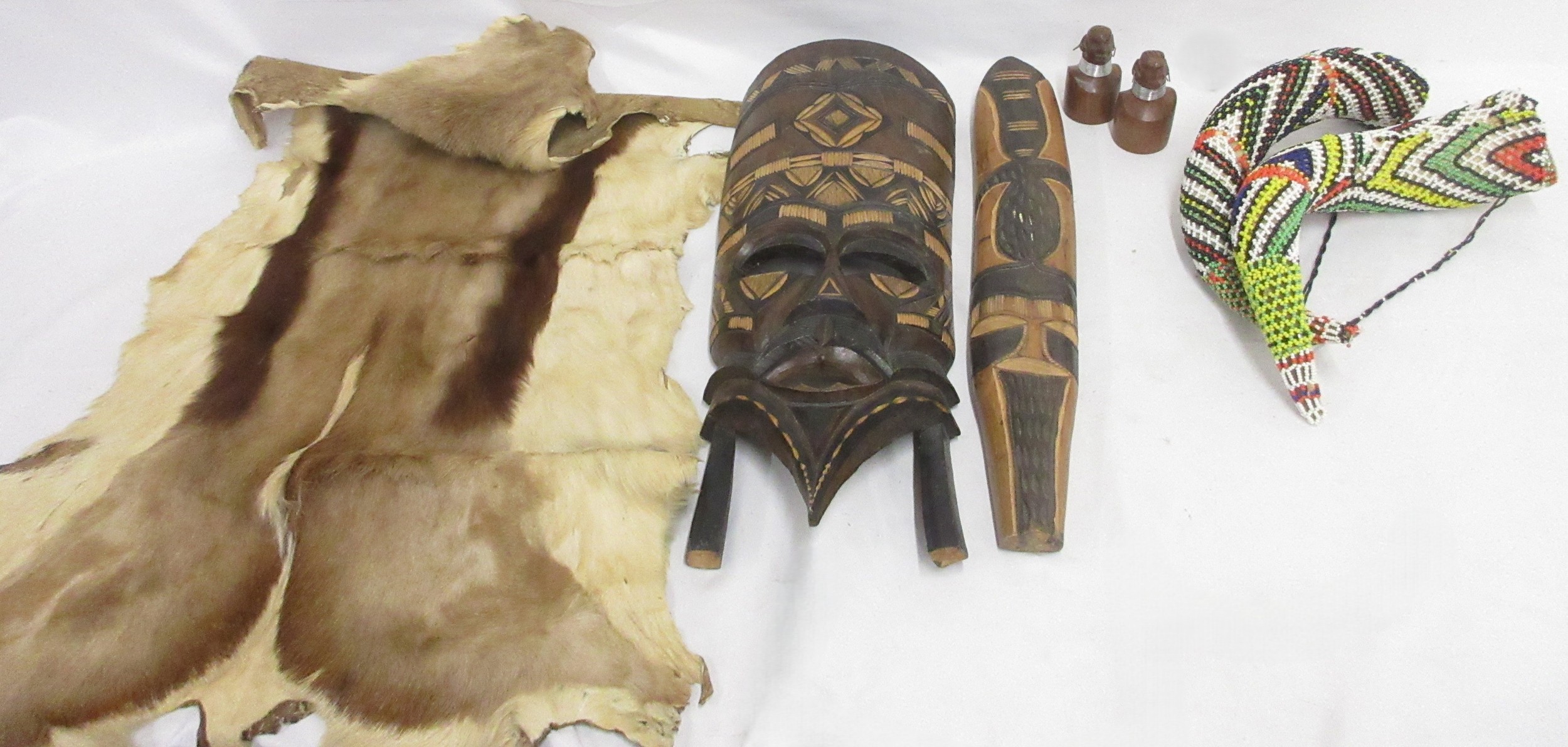African mask, beaded horns, springbok hide, flag, and salt and pepper ...