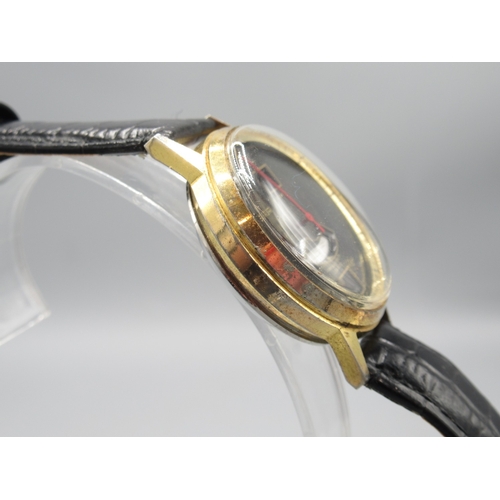 472 - Buler gold plated jump hour wristwatch with date, signed black dial with centre seconds, signed snap... 