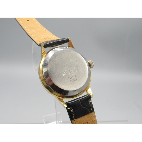 472 - Buler gold plated jump hour wristwatch with date, signed black dial with centre seconds, signed snap... 