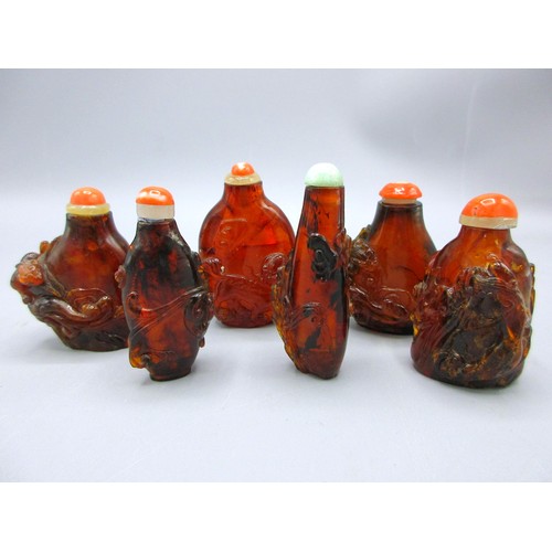 Collection of Chinese carved red amber snuff bottles, circa 19th/20 Century, Qing dynasty or later; with slender, some flattened forms, standing on oval feet; showcasing high-relief carvings of Chinese (lizard) water dragons extending upward, foliate scrolls, waves & swirls throughout, plus a traditional foo dog/imperial guardian lion to the larger example; further decorated with coral-coloured caps, one with pale green jadeite cabochon seal and bone scoop spatulas to the interior, together with an associated wooden stand; approx. W 3.5cm x H 6cm x D 2cm (largest), total weight circa 85.5g (without stand), provenance from a private collection, etc. Qty. 6

Bradleys Shipping £38.00 plus vat (UK)