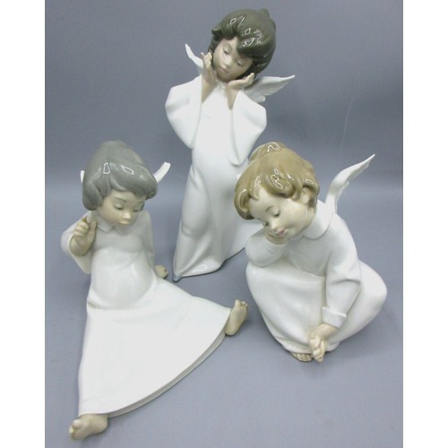 874 - Three Lladro porcelain angelic figures inc. 'Mime Angel' (no. 4959) depicted standing with a puzzled... 