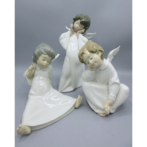 874 - Three Lladro porcelain angelic figures inc. 'Mime Angel' (no. 4959) depicted standing with a puzzled... 