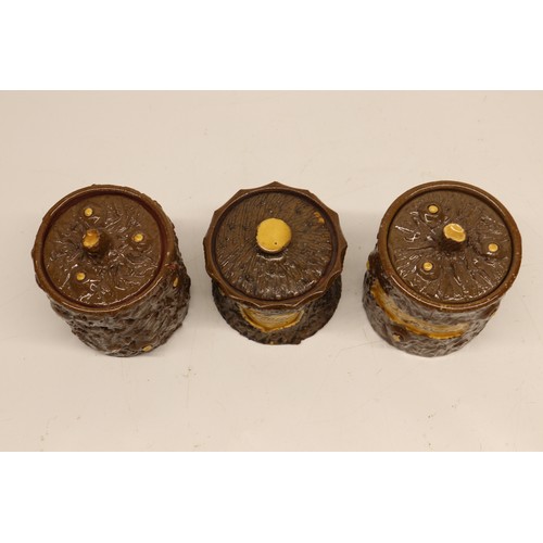 1014 - Three earthenware jars; pair of straight sided jars with cut branch and bark texture surface, one in... 
