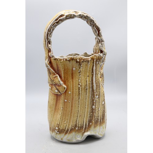 1048 - Ruthanne Tudball (1948-) top handled basket vase, soap glaze, impressed mark to the base, H29.5cm
Br... 