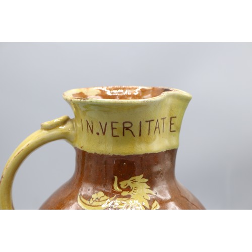 1060 - North Devon slipware harvest jug, scrolled handle, inscribed 'IN VERITATE TRIUMPHO', dated 1904, H24... 